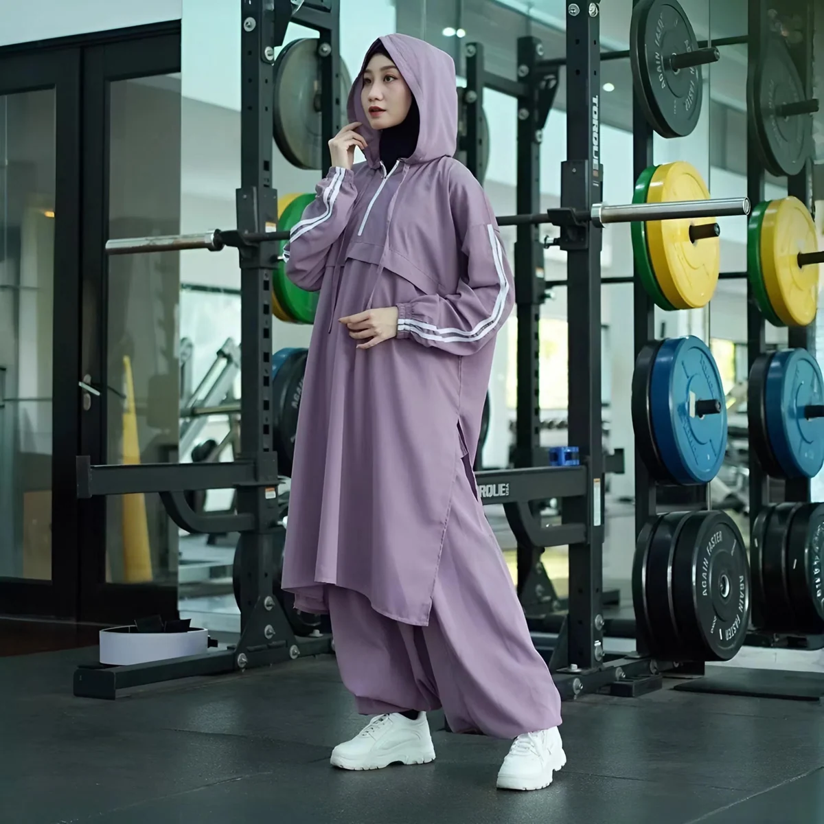 Woman wearing a lilac modest activewear outfit in a gym