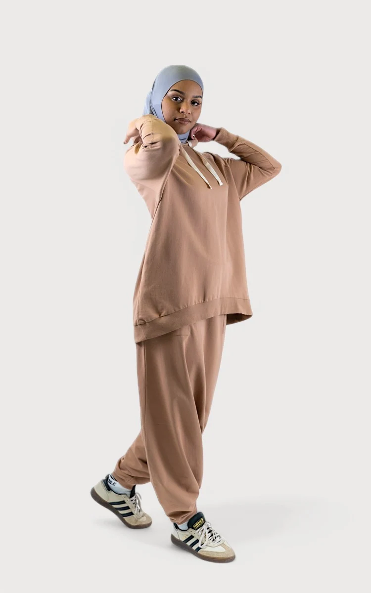 Woman wearing a comfortable sand-colored hoodie and relaxed trousers